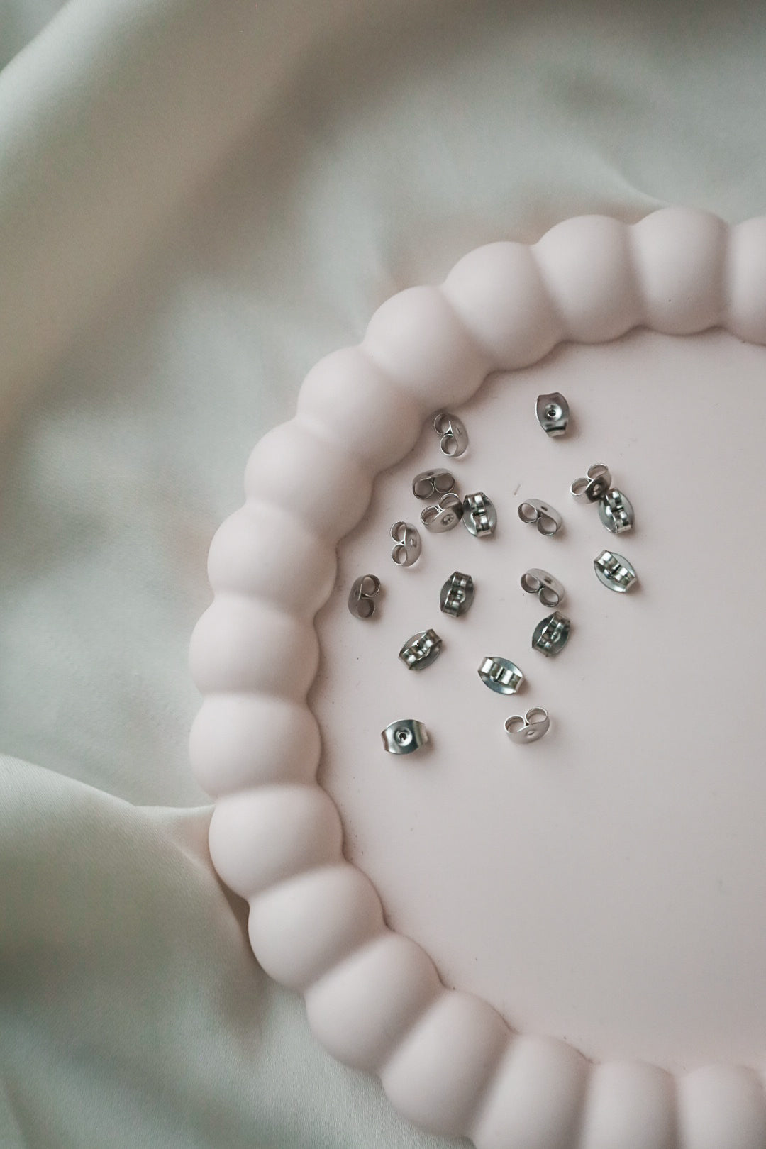 Korvakorun taustat, ruostumaton teräs